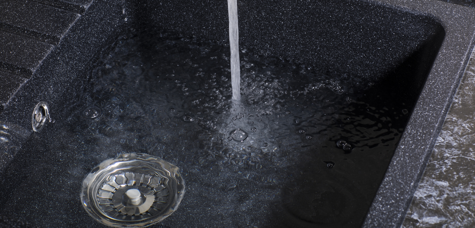 Water flows into a sink, demonstrating a reverse osmosis system working to reduce salt from household water.