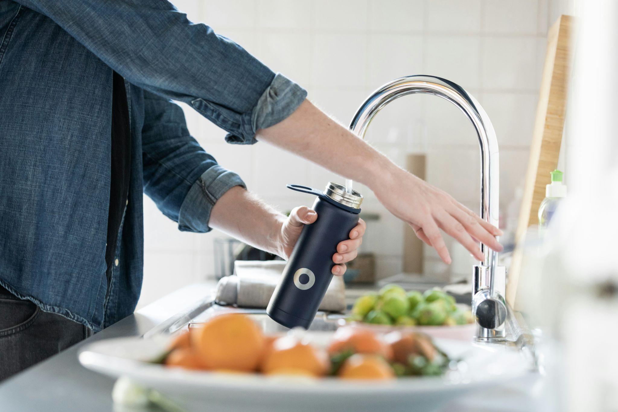 A compact reverse osmosis system under a kitchen sink, illustrating how to demineralize water for clean, mineral-free hydration at home.
