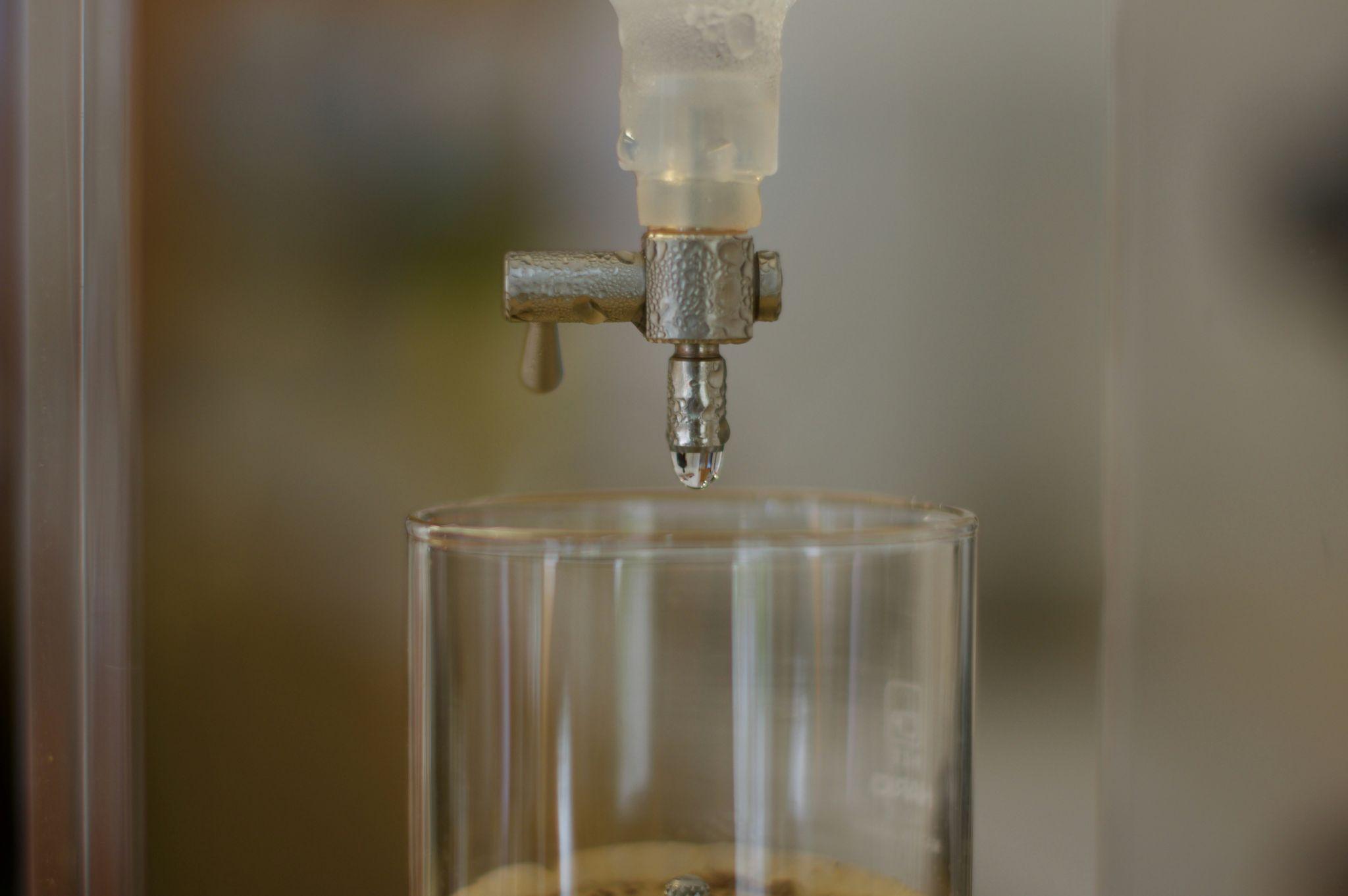 Whitish-gray scaling on a faucet from hard water, demonstrating the need for demineralized water to prevent mineral buildup.