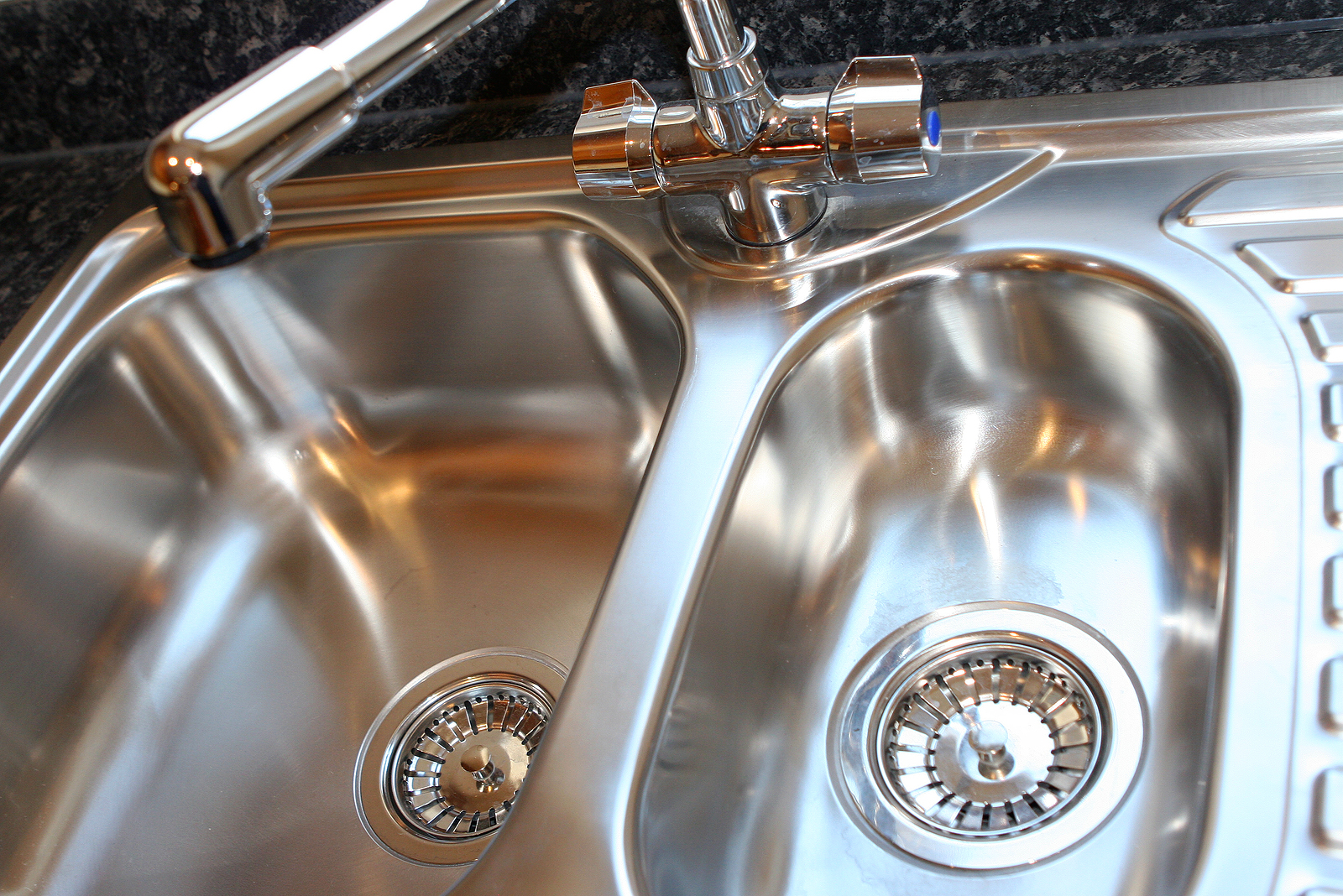 Spotless stainless steel double sink and shiny faucet showing no hard water stains