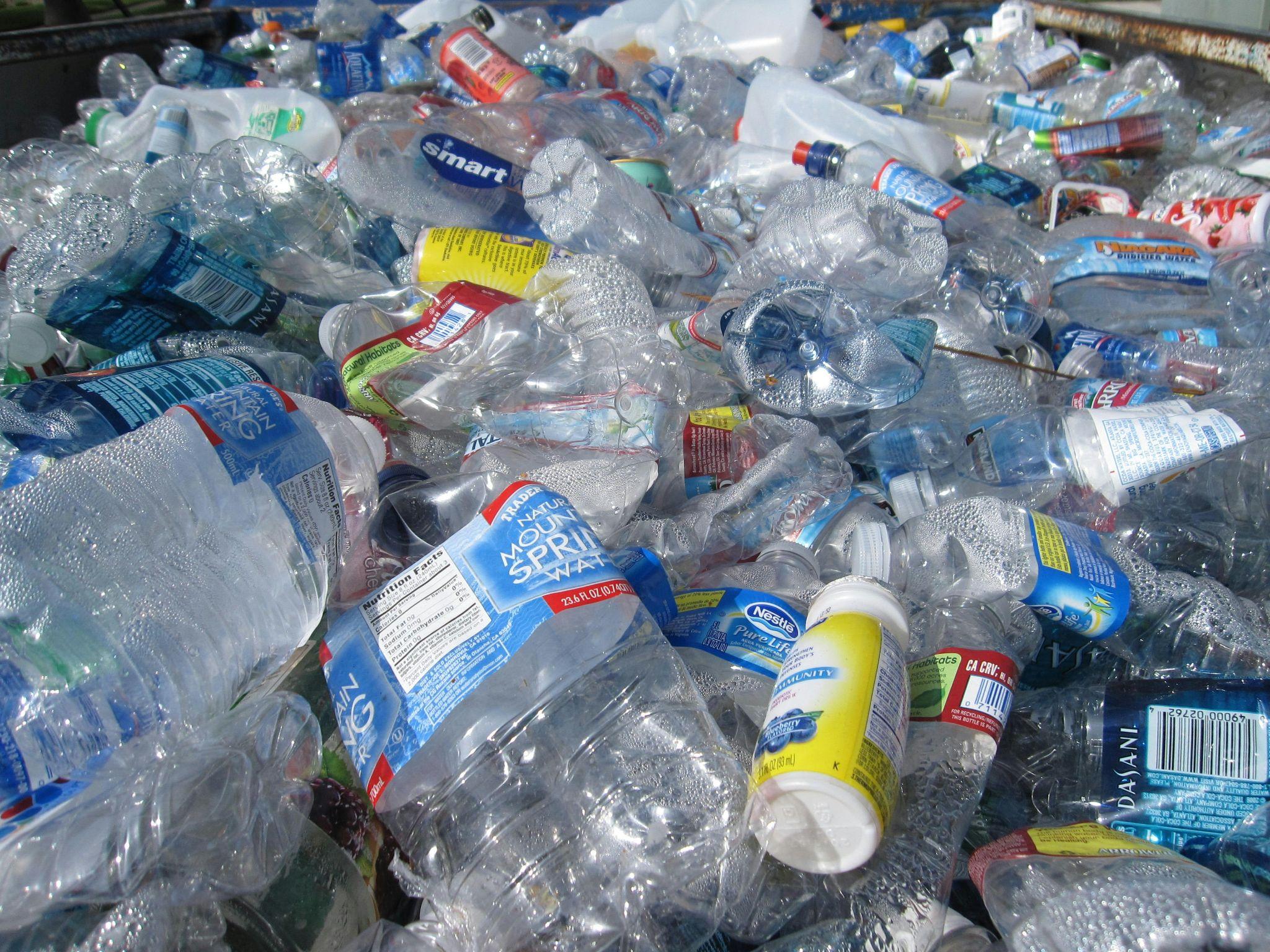 A collection of used plastic water bottles in a recycling bin, reflecting efforts to reduce the environmental impact of bottled water.