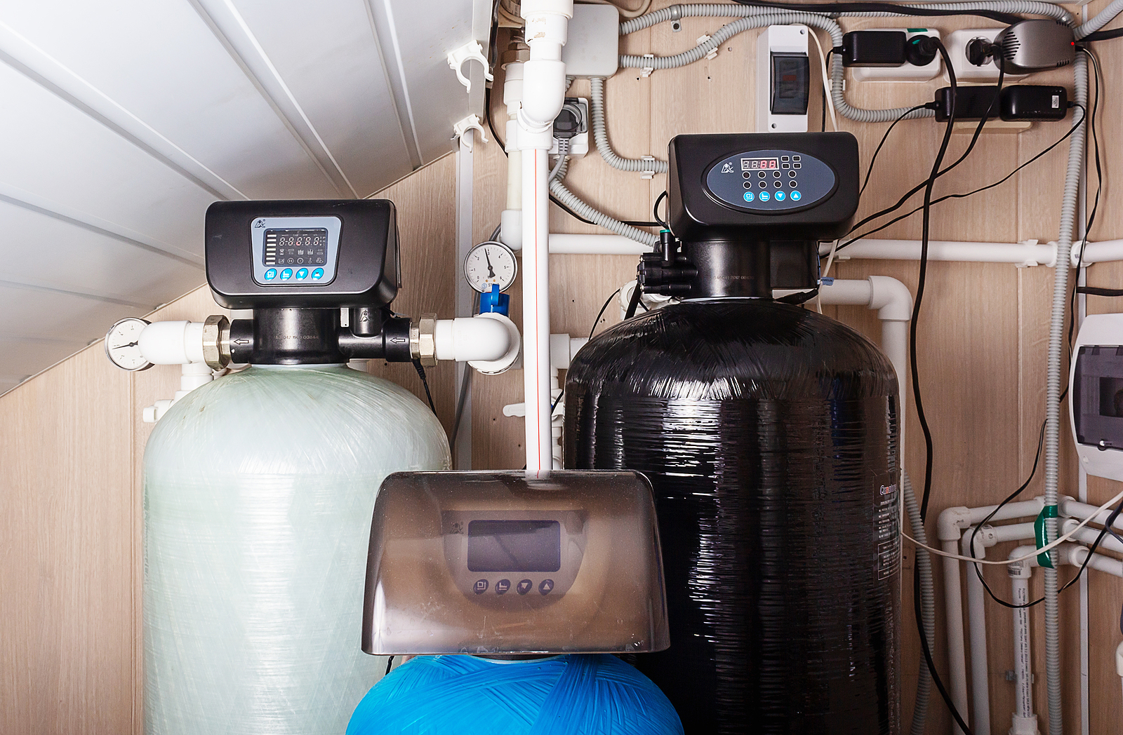 Twin-tank water softener system installed in a utility room for comprehensive household mineral removal and water treatment