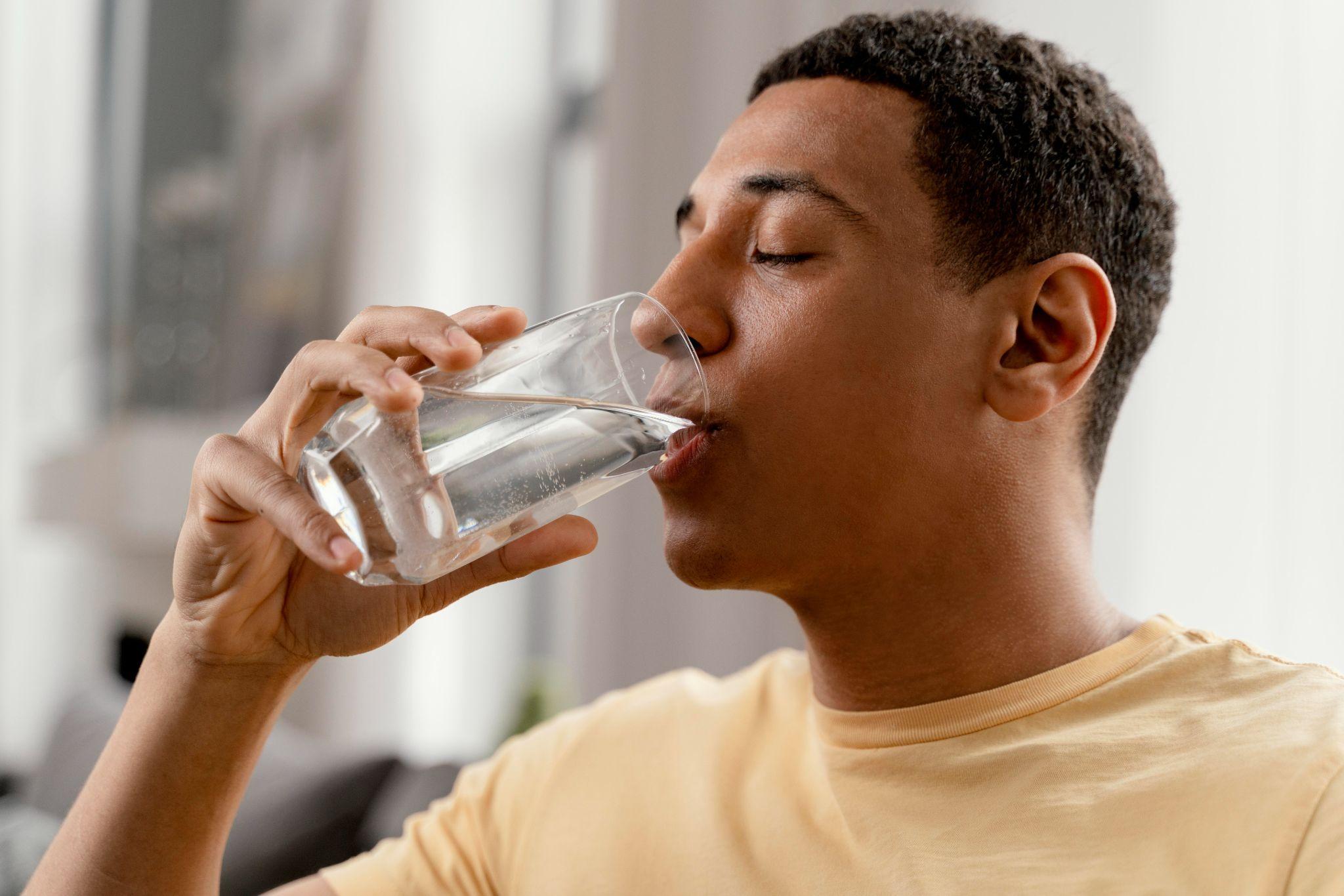Phoenix homeowner drinking a glass of soft water after a Rayne Water installation.
