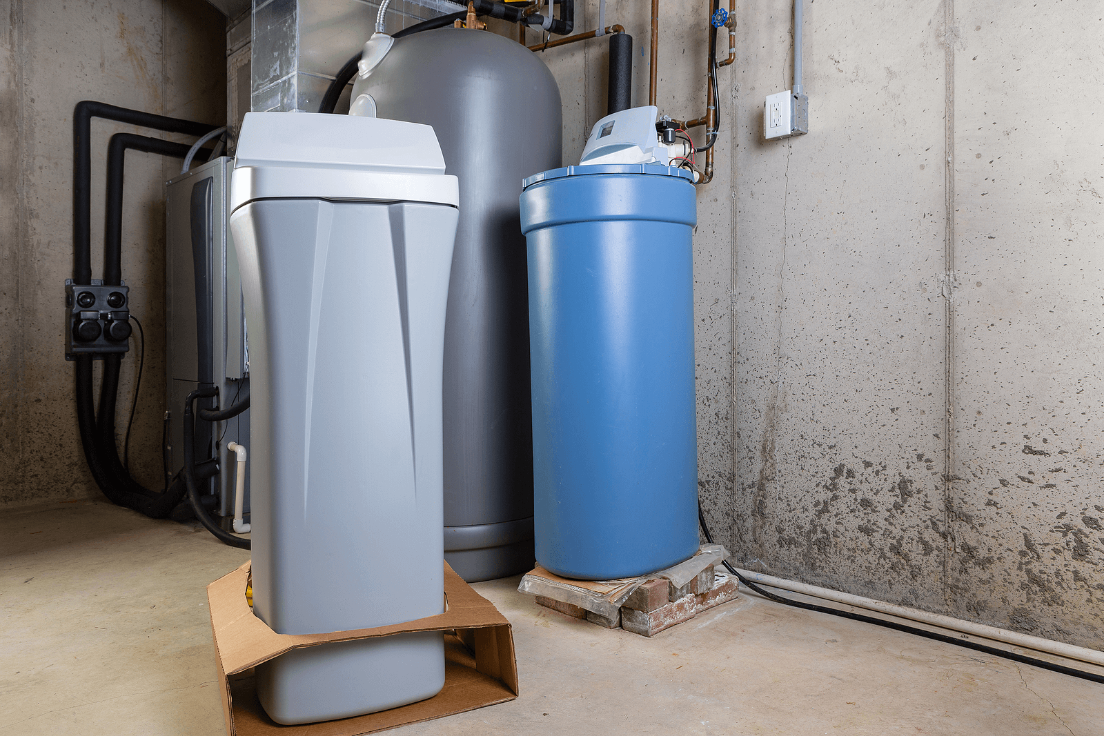 Old blue brine tank next to a new slim water softener during a Phoenix replacement install.